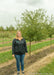 Golden Raindrops Crabapple in the nursery with a person standing next to it for a height comparison.